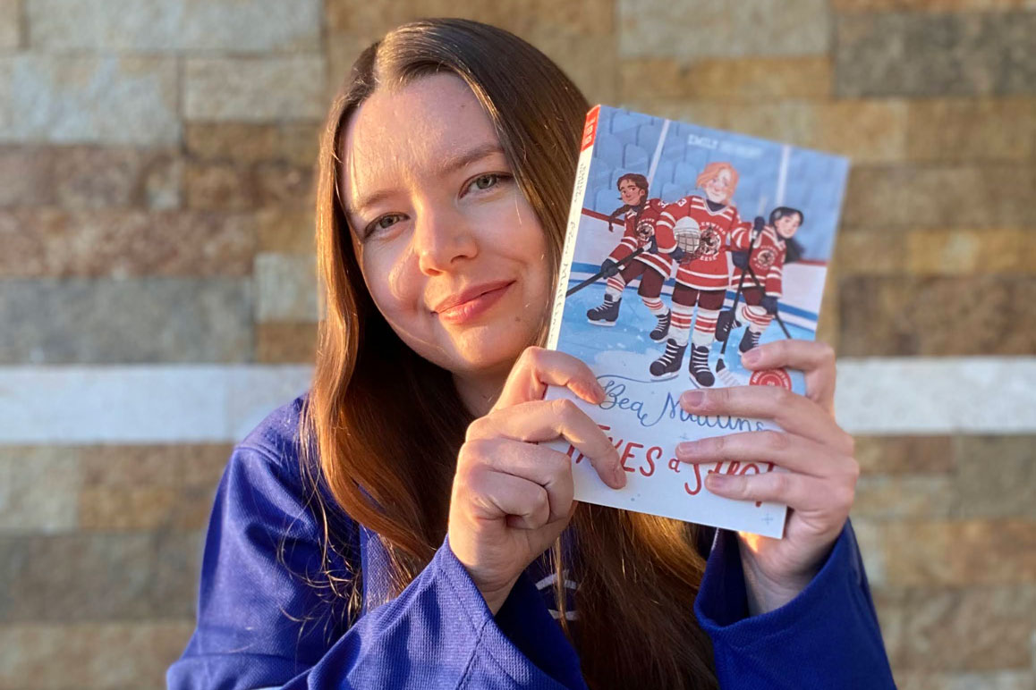 Emily holding her new children’s book Bea Mullins Takes a Shot. 